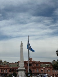 a statue with a flag flying in front of it