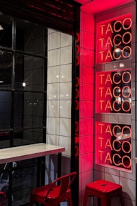 a restaurant with a red neon sign on the wall